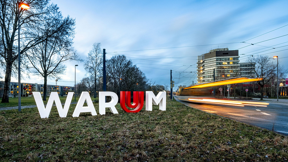 Die Buchstaben WARUM stehen als Skulptur auf einer Grünfläche auf dem Campus der Universität Bremen