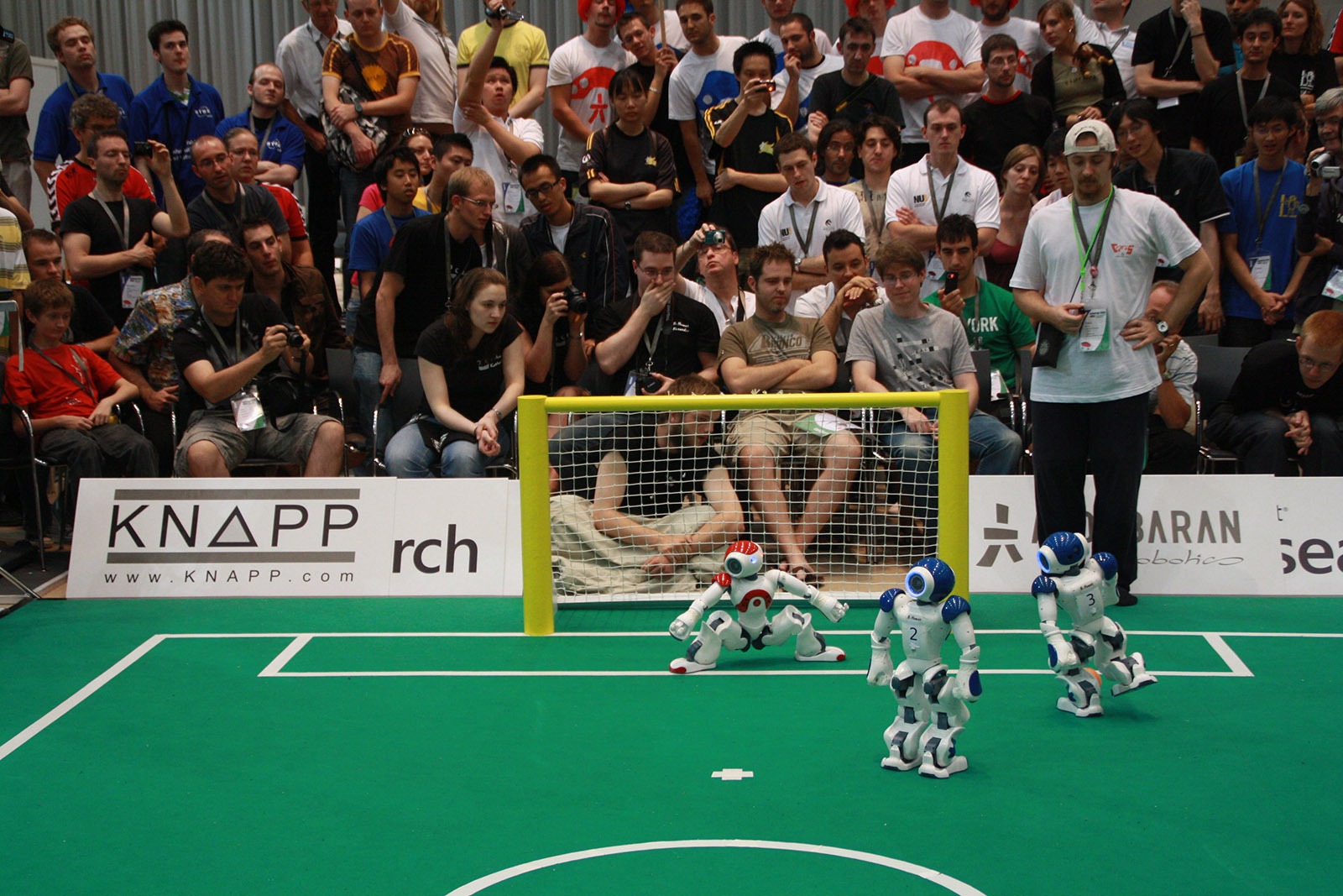 Zwei Roboter des Teams B-Human spielen Roboterfußball auf einem Spielfeld
